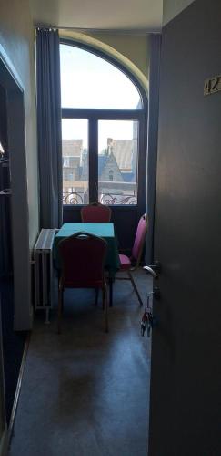 a room with a table and chairs and a window at hotel Melissa in Péruwelz