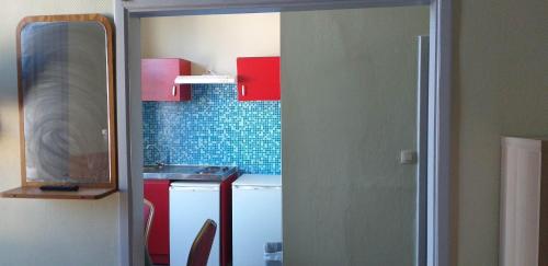 a small kitchen with a sink and red cabinets at hotel Melissa in Péruwelz