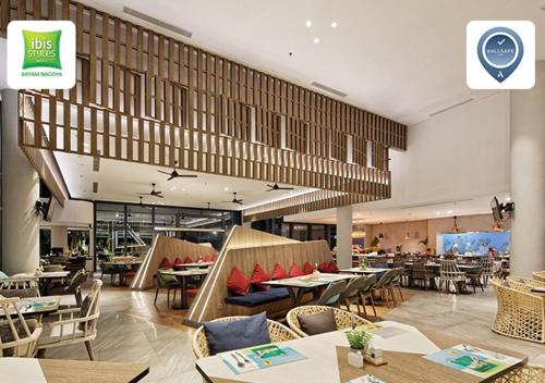 a dining room with tables and chairs and a restaurant at ibis Styles Batam Nagoya in Nagoya