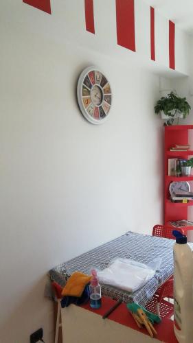a room with a table with a clock on the wall at Porta Maggiore GH Locazione Turistica in Rome