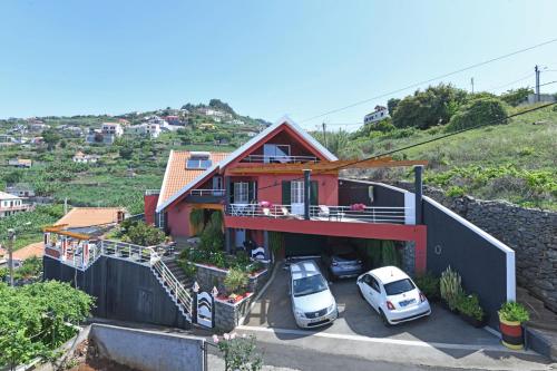 a house with two cars parked in a parking lot at Ponta do Sol Villa in Ponta do Sol