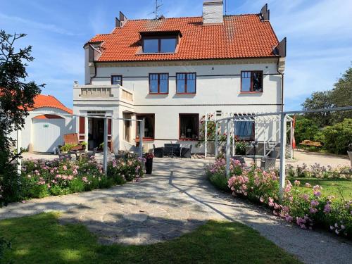 una gran casa blanca con techo rojo en Norrehus en Klippan