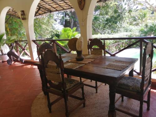 a dining room with a wooden table and chairs at Sunset villas Tropical Garden House in Kilifi