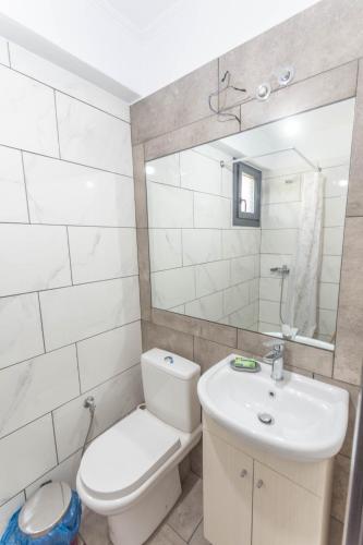 a bathroom with a toilet and a sink and a mirror at DNS Apartment in Kavála