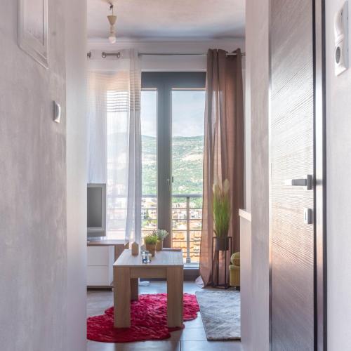 a living room with a table and a large window at DNS Apartment in Kavála