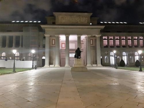 a statue in front of a building at night at Hostal Dulcinea in Madrid