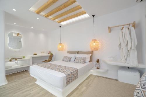 a white bedroom with a white bed and a sink at Naxian Spirit Inn in Naxos Chora