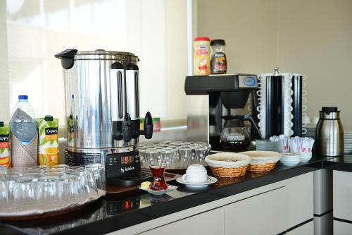 una cucina con una macchina per il caffè e dei bicchieri su un bancone di Hotel Star Royal a Igdır