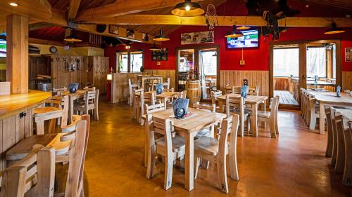 a restaurant with wooden tables and chairs and a bar at Roadcamp - American Motel & Sportsbar in Marl