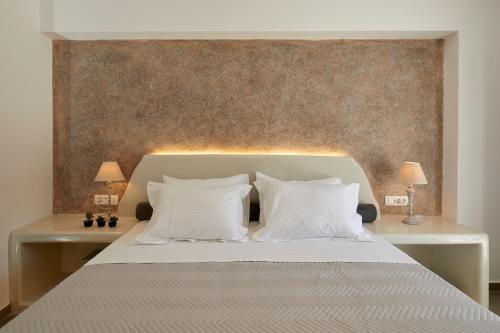 a bedroom with a white bed with two white pillows at Blue Sea Hotel in Kamari