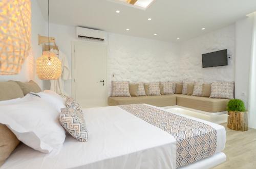 a white bedroom with a bed and a couch at Naxian Spirit Inn in Naxos Chora