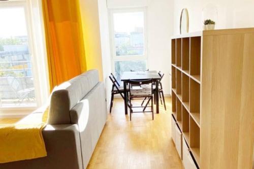 - un salon avec un canapé et une table à manger dans l'établissement Cosy and Quiet flat close to Disneyland Paris, à Montévrain