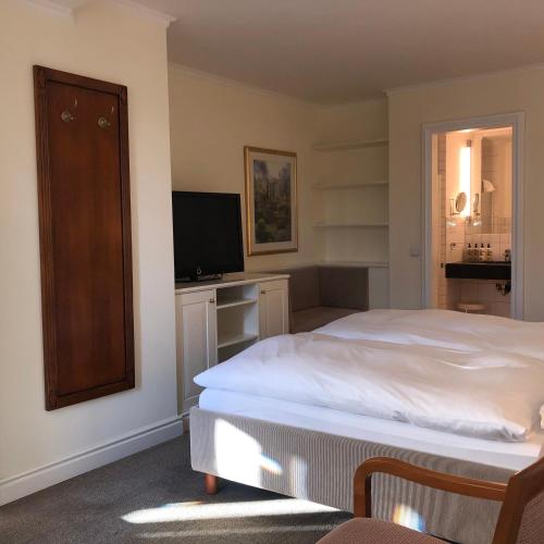 Hotel Scherf Residenz في باد ليبسبرنغ: غرفة نوم بسرير وتلفزيون بشاشة مسطحة