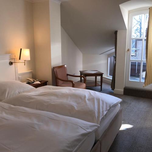 a hotel room with a bed and a chair and a window at Hotel Scherf Residenz in Bad Lippspringe