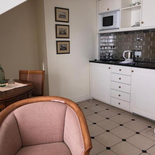 a kitchen with a chair and a table and a microwave at Hotel Scherf Residenz in Bad Lippspringe