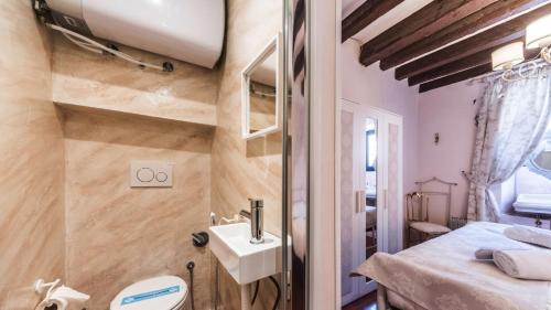 uma casa de banho com um lavatório e um WC num quarto em Residenza La Salute em Veneza