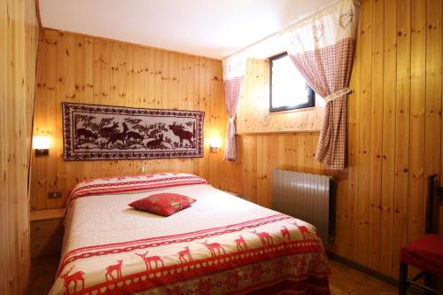 um quarto com uma cama num quarto com paredes de madeira em Lo Stambecco Holiday Apartment - Affitti Brevi Italia em Brusson