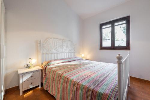 Habitación blanca con cama y ventana en Appartamento in Villa Erica, en Torre delle Stelle