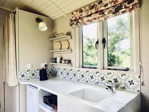 a kitchen with a sink and a window at The Oaks Glamping - Jasper's Shepherds Hut in Colkirk