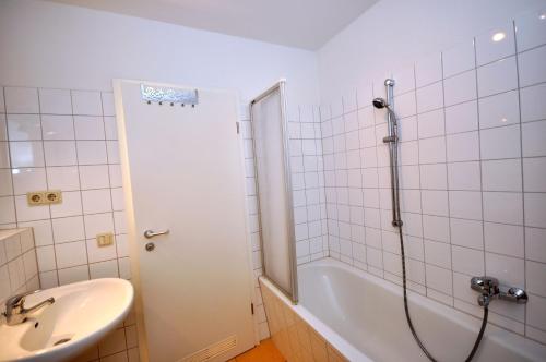 ein Badezimmer mit einer Dusche, einer Badewanne und einem Waschbecken in der Unterkunft Komfort-Ferienwohnung Meeresrauschen by Meer-Ferienwohnungen in Sassnitz