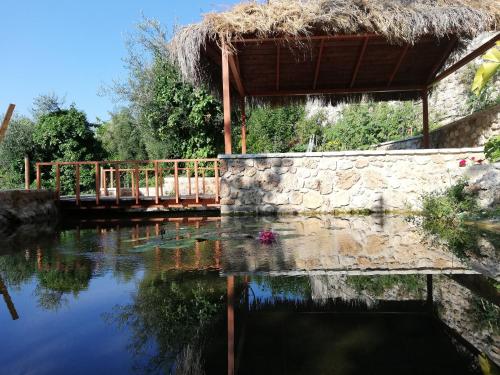 a bridge over a river with a thatch roof at Filoxenia Sea View in Parga