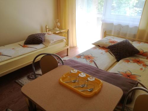 a room with two beds and a table with glasses on it at Pokoje u Łazarczyków in Szczawnica