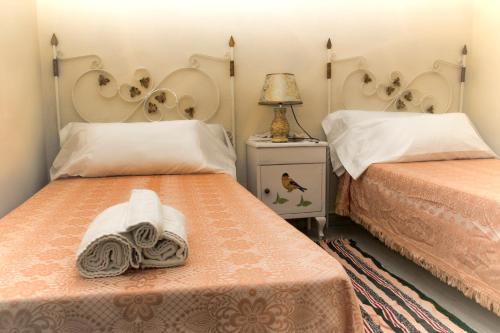 a bedroom with two beds and a lamp on a table at Apts la cañada birding con encanto y patio en monfrague torrejon el Rubio in Torrejón el Rubio