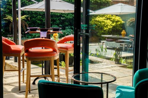 a group of chairs and tables in front of a window at Great Fosters - Near Windsor in Egham