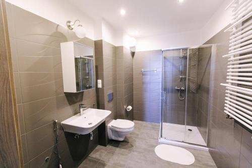 a bathroom with a toilet, sink and shower at Renttner Apartamenty in Warsaw