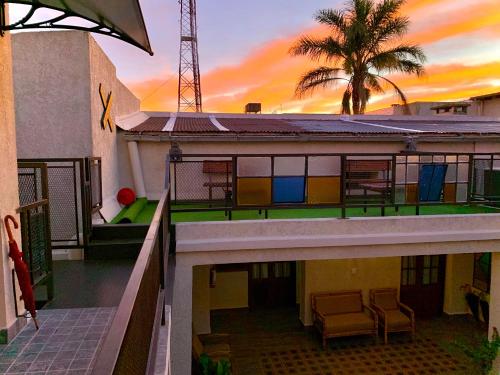 a house with a balcony with a palm tree at Hotel FK Paso de los Toros - Hotel Boutique in Santa Isabel