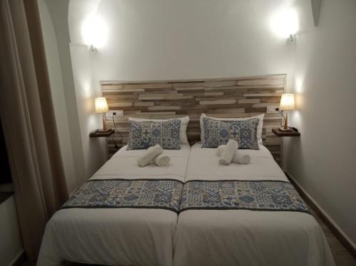 a bedroom with a large bed with two pillows at Alojamientos rurales La Barca del tío Vito in Peloche