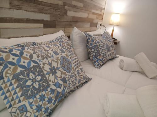 a white bed with two pillows and a couch at Alojamientos rurales La Barca del tío Vito in Peloche