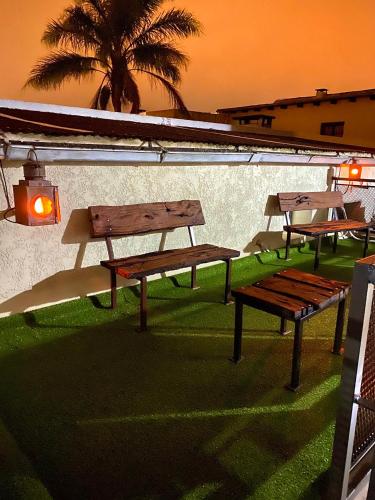 a group of benches sitting on the grass at Hotel FK Paso de los Toros - Hotel Boutique in Santa Isabel