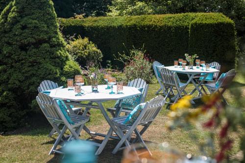 a group of tables and chairs in a garden at Barnett Hill Hotel in Guildford