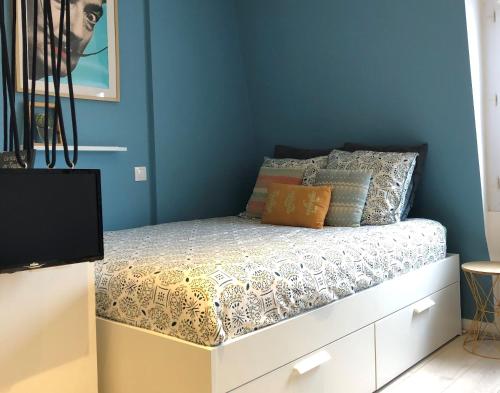 - une chambre dotée d'un lit avec un mur bleu dans l'établissement Le Studio 12, à Le Touquet-Paris-Plage