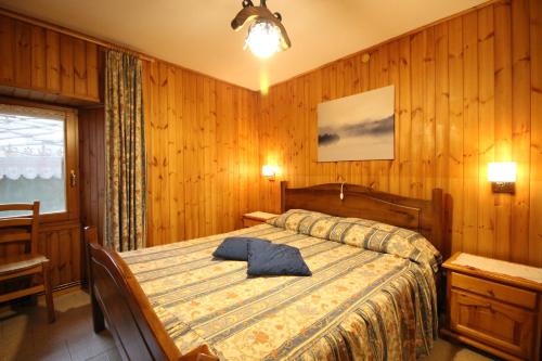 una camera da letto con un letto con un cuscino blu di Trilocale in Centro La Marmotta - Affitti Brevi Italia a Brusson