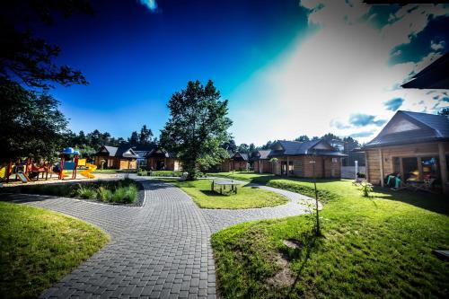 a cobblestone walkway in a yard with houses at Domki Osada Bacówka Radawa & SPA in Radawa