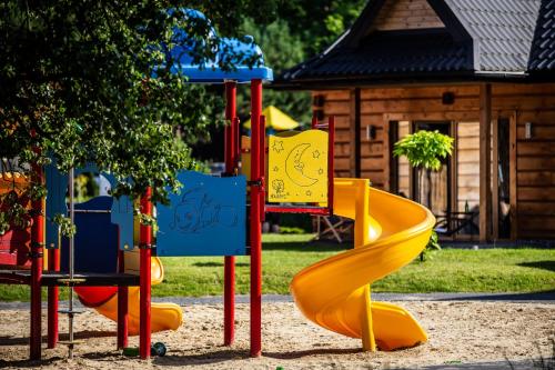 a playground with a slide in a park at Domki Osada Bacówka Radawa & SPA in Radawa