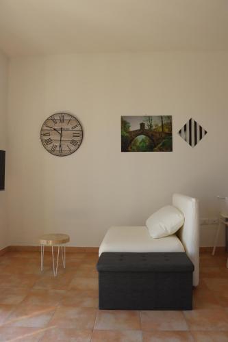 a room with a bed and a clock on the wall at Myricae in Viareggio