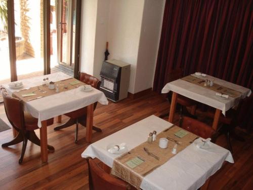 two tables and chairs in a room with at Uitsigpark Guest@home4U in Centurion