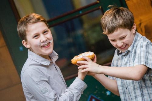 Dos chicos están comiendo una rosquilla. en Biohof Grissenberger en Abetzdorf