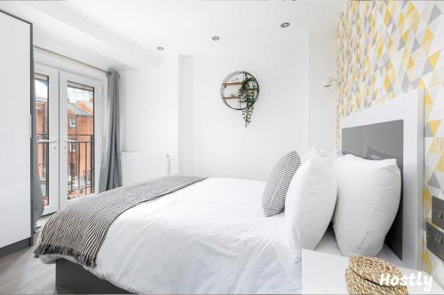 a white bedroom with a large white bed with pillows at Tulip Apartment - The Heart of Reading Town Centre in Reading