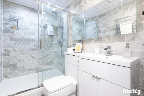 La salle de bains est pourvue d'un lavabo et d'une douche. dans l'établissement Tulip Apartment - The Heart of Reading Town Centre, à Reading