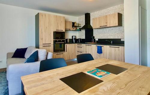 Il comprend un salon avec une table en bois et une cuisine. dans l'établissement Le petit marquisat à deux pas du lac, à Annecy