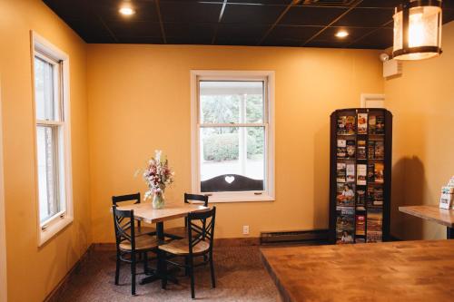 a dining room with a table and chairs and a window at Country Squire Inn and Suites in New Holland