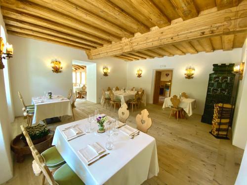a dining room with white tables and chairs and wooden ceilings at Rifugio Ospitale in Cortina dʼAmpezzo