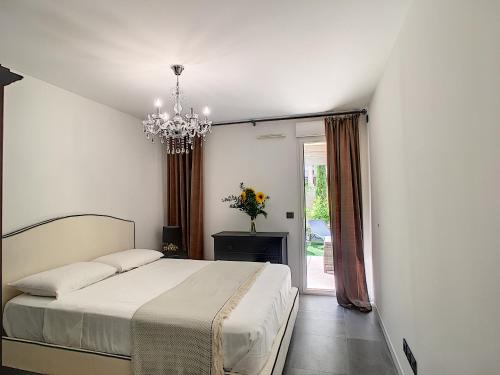 une chambre avec un lit et un lustre dans l'établissement Palm Beach apartment with a pool in the residence, à Cannes