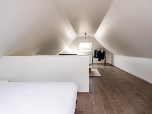 ein Schlafzimmer mit einem weißen Bett und einer Treppe in der Unterkunft B&B Welness Sport and Pleasure in Laarne