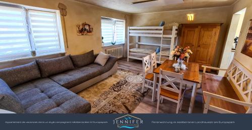 a living room with a couch and a table and a bunk bed at Ferienwohnung Jennifer in Rust