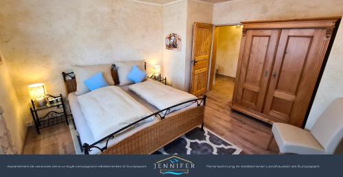 een slaapkamer met een groot bed met blauwe kussens bij Ferienwohnung Jennifer in Rust